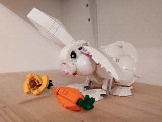 A photo of an assembled LEGO set of a rabbit, a carrot and a flower.